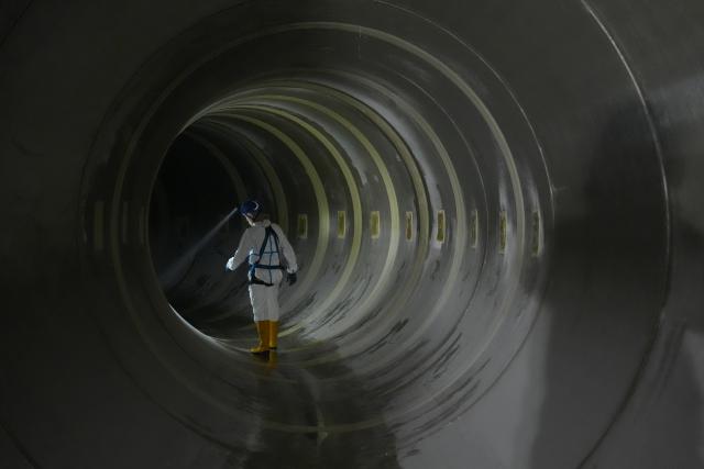 10 June 2026, Hamburg: A Hamburg Wasser employee walks through the Kuhmuehlen-Stammsiel pipe under the subway viaduct at Landungsbruecken during a construction site tour. Prefabricated pipes were inserted into the masonry sluice for the renovation project, which was highlighted as the company's Executive Board presented its financial balance sheet for the 2025 fiscal year. Photo: Marcus Brandt/dpa
