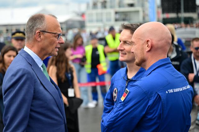 SYMBOL - 10 June 2026, Brandenburg, Schoenefeld: Friedrich Merz (L), German Chancellor, chats with Matthias Maurer (C), an ESA astronaut, and Alexander Gerst (R), an ESA astronaut, during a tour of the International Aerospace Exhibition (ILA). Photo: Sebastian Gollnow/dpa