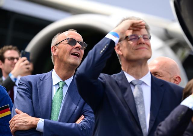 10 June 2026, Brandenburg, Schoenefeld: German Chancellor Friedrich Merz (L) and German Minister of Transport Patrick Schnieder watch parachutists during a tour of the International Aerospace Exhibition (ILA). Photo: Sebastian Gollnow/dpa