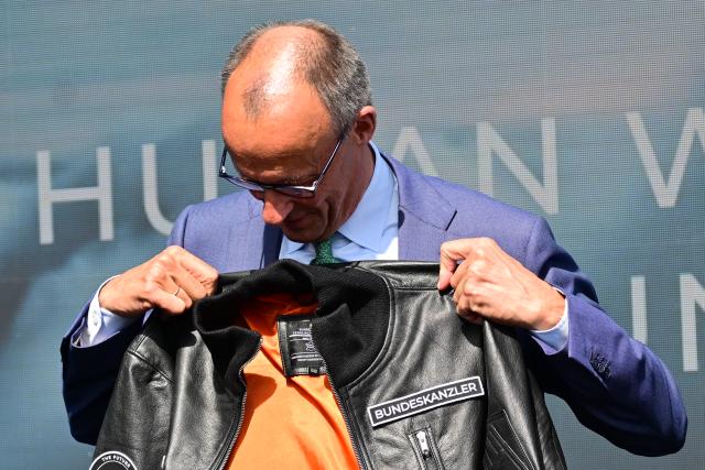 SYMBOL - 10 June 2026, Brandenburg, Schoenefeld: Friedrich Merz, German Chancellor, looks at a jacket he received from Quantum-Systems during a tour of the International Aerospace Exhibition (ILA). Photo: Sebastian Gollnow/dpa