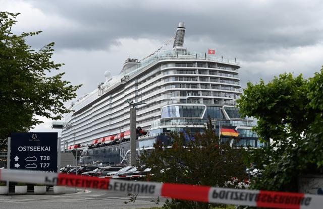 10 June 2026, Schleswig-Holstein, Kiel: Passengers wait to board a cruise ship as parts of the vessel Mein Schiff Relax and the Ostseekai terminal are evacuated on Wednesday. Photo: Katrin Luxenburger/dpa