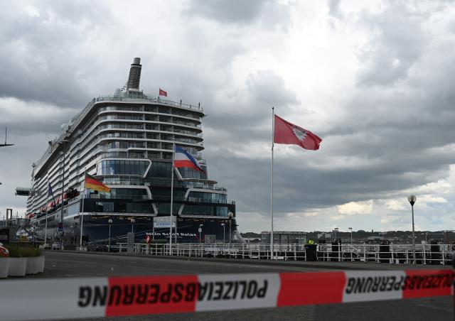 10 June 2026, Schleswig-Holstein, Kiel: Passengers wait to board a cruise ship as parts of the vessel Mein Schiff Relax and the Ostseekai terminal are evacuated on Wednesday. Photo: Katrin Luxenburger/dpa