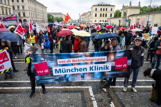 10 June 2026, Bavaria, Munich: Demonstrators hold banners during a Verdi rally on Odeonsplatz against the federal government's planned austerity measures in the public health insurance system. Photo: Lukas Barth-Tuttas/dpa