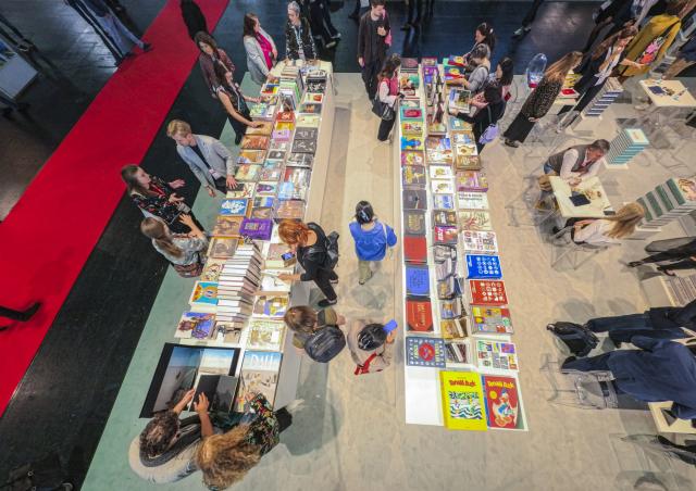 FILED - 16 October 2025, Hesse, Frankfurt/Main: FILE PHOTO - Trade visitors browse literature at a book table during the Frankfurt Book Fair. Photo: Andreas Arnold/dpa