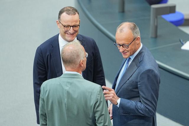 11 June 2026, Berlin: Friedrich Merz (R), German Chancellor, Jens Spahn (C), leader of the CDU/CSU parliamentary group in the Bundestag, and Matthias Miersch, leader of the SPD parliamentary group, speak in the plenary chamber of the Bundestag. Photo: Michael Kappeler/dpa
