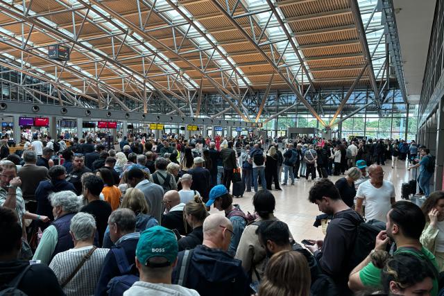 12 June 2026, Hamburg: People stand in a hall at Hamburg Airport after the airport's security area was evacuated due to a police situation, requiring all passengers to leave the area beyond the security checkpoints according to a spokesperson for the Federal Police, in Hamburg. Photo: Frank Molter/dpa