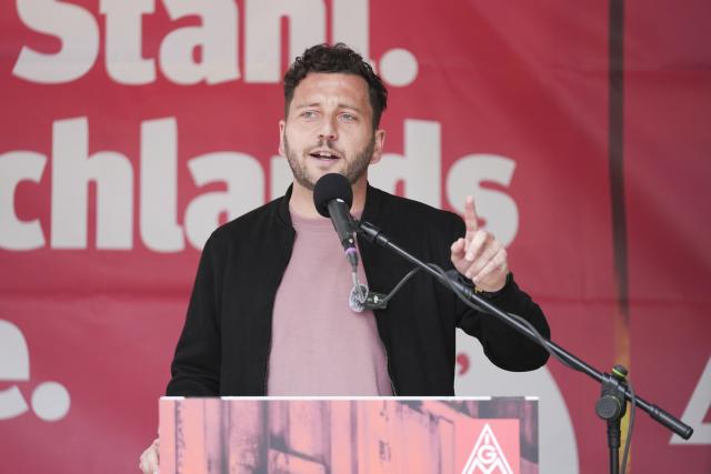 12 June 2026, Berlin: Felix Banaszak, the federal chairman of Alliance 90/The Greens, speaks with participants at an IG Metall union rally in Berlin, Germany, where hundreds of people are demonstrating for the future of the steel industry. Photo: Sven Kaeuler/dpa