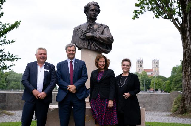 13 June 2026, Bavaria, Munich: Dietmar Holzapfel (left to right), founder and owner of the Deutsche Eiche, Markus Soeder (CSU), Minister-President of Bavaria, Verena Dietl (SPD), Third Mayor of the City of Munich, and Jeanne-Marie Ehbauer, City of Munich Building Commissioner, attend the unveiling of the new Ludwig II monument at the Cornelius Bridge. King Ludwig II died 140 years ago, on June 13, 1886. Photo: Sven Hoppe/dpa