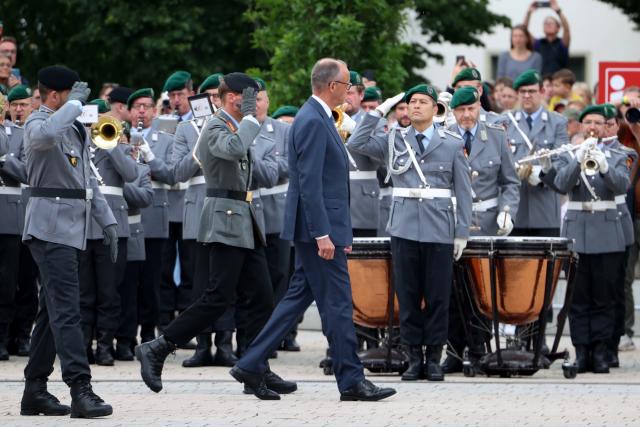 13 June 2026, North Rhine-Westphalia, Medebach: Friedrich Merz (C), Germany's Chancellor, and Christian Freuding (R), Lieutenant General and Inspector General of the Army, walk past the recruits during the Bundeswehr's ceremonial oath-taking ceremony. Recruits from the 21st Armored Brigade in Ahlen and Unna take their oath of service. Photo: Christoph Reichwein/dpa