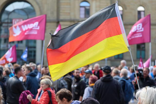 13 June 2026, Saxony-Anhalt, Magdeburg: Participants in a BSW rally, held under the slogan "Merz Must Go! Against Energy Price Gouging and the Economic Crisis," are gathered on the station square in the state capital. Photo: Peter Gercke/dpa