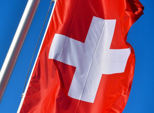 FILED - 28 February 2017, Brandenburg, Ruedersdorf: FILE PHOTO - The national flag of Switzerland can be seen against a blue sky in Ruedersdorf. Photo: Patrick Pleul/dpa-Zentralbild/dpa