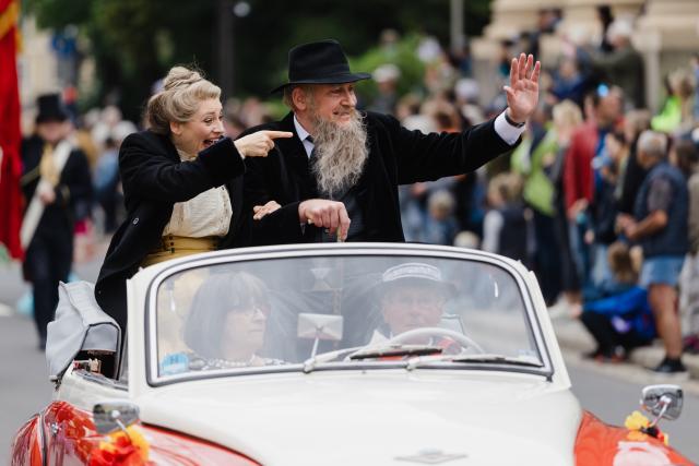 14 June 2026, Thuringia, Meiningen: Participants dressed as the "Theater Duke" and Helene, Baroness von Heldburg, wave from a vintage car during a parade celebrating the 200th birthday of Georg II, the "Theater Duke" of Saxe-Meiningen.
About 50 scenes and some 2,000 participants bring the life and work of the "Theater Duke" to life during the parade. Photo: Michael Reichel/dpa