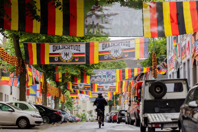 PRODUCTION - 15 June 2026, North Rhine-Westphalia, Essen: Flags flutters along Rullich street in Essen-Altendorf. The 70-years-old German football fan "Flaggen-Achim" stands has once again transformed his street into a sea of flags for the World Cup. Photo: Rolf Vennenbernd/dpa