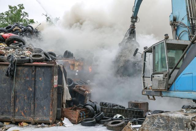 16 June 2026, Bavaria, Dettelbach: Firefighters are using a turntable ladder to extinguish a fire in a pile of scrap tires and cables on the grounds of a waste disposal company. Authorities are warning residents due to heavy smoke. Photo: Daniel Löb/dpa