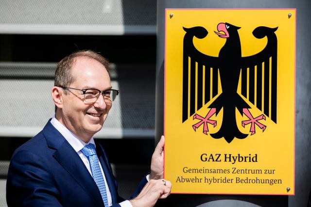 16 June 2026, Berlin: Alexander Dobrindt, German Minister of the Interior, symbolically screws on the plaque at the inauguration of the Joint Center for Countering Hybrid Threats (GAZ Hybrid). The new defense center will be located on the premises of the Federal Office for the Protection of the Constitution in Berlin-Treptow. Photo: Christoph Soeder/dpa