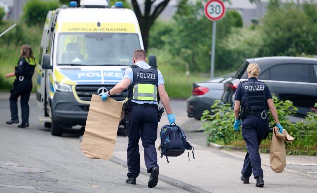 17 June 2026, North Rhine-Westphalia, Luedenscheid: Police officers work at the scene after a school bus hit a nine-year-old child. According to the initial investigation, the child reportedly ran out into the street suddenly and was struck by the bus. Photo: Bernd Thissen/dpa