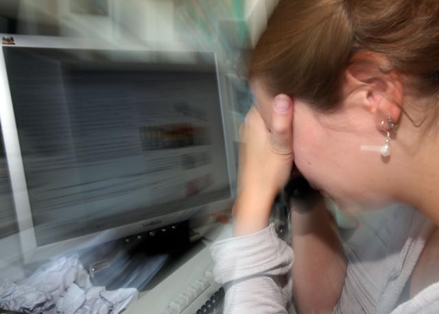 FILED - 23 June 2010, North Rhine-Westphalia, Cologne: FILE PHOTO - A woman buries her face in her hands at her workplace in Cologne. Photo: Oliver Berg/dpa
