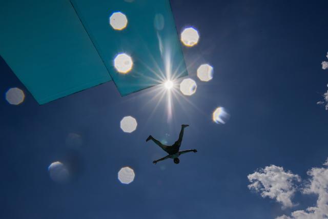 18 June 2026, North Rhine-Westphalia, Cologne: A person jumps off the diving platform at the Stadionbad during a sunny day. Photo: Rolf Vennenbernd/dpa
