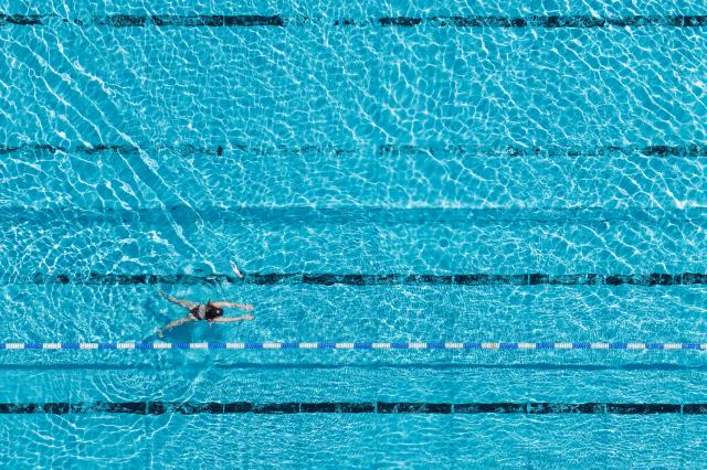 18 June 2026, Saxony, Grossroehrsdorf: An aerial view shows a swimmer cooling off at the Massenei Pool. Photo: Sebastian Kahnert/dpa