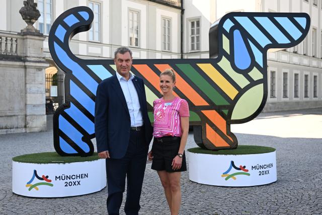 18 June 2026, Bavaria, Munich: Minister President of Bavaria Markus Soeder (L) and dressage rider and Olympic champion Jessica von Bredlow-Werndl pose after a press conference in front of Nymphenburg Palace to present to representatives of top sports federations the unique features and opportunities Munich offers as a national candidate for the Summer Olympics, as well as the bid concept. Photo: Sven Hoppe/dpa