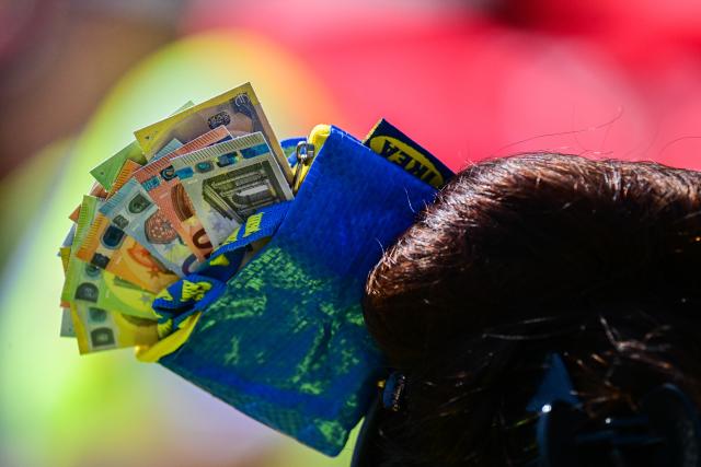 19 June 2026, Berlin: During a nationwide warning strike in the collective bargaining round of the United Services Union (ver.di), a woman is wearing a small IKEA bag filled with play money in her hair. Photo: Sebastian Christoph Gollnow/dpa