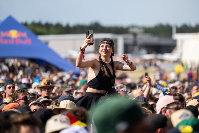 19 June 2026, Baden-Wuerttemberg, Neuhausen ob Eck: A festivalgoer takes photos at the opening of the Southside Festival during a performance by the hip-hop band PA69. Photo: Silas Stein/dpa