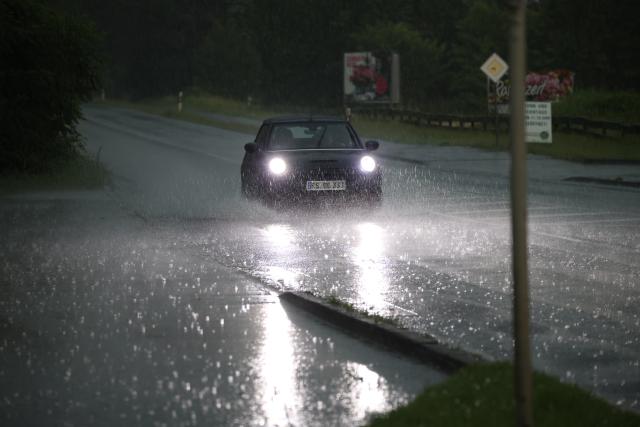 19 June 2026, North Rhine-Westphalia, Wuppertal: A car is driving through the large puddles on a federal highway in the Bergisches Land region of Wuppertal. Thunderstorms and heavy rain are forecast for the region. Photo: Christoph Reichwein/dpa