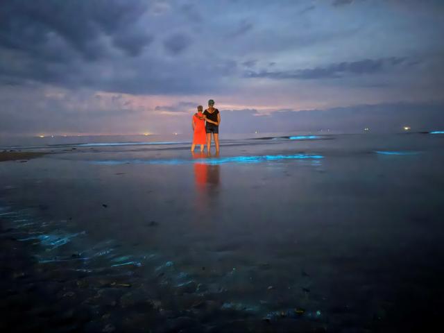 20 June 2026, Lower Saxony, Norderney: Two women are watching the sea glow over the North Sea. Photo: Volker Bartels/dpa