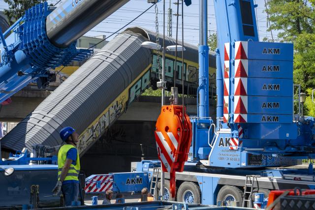 20 June 2026, Bavaria, Munich: Rescue operations were underway for two cars of a freight train that had fallen about five meters off a bridge during the night. According to police, two freight trains had previously collided while shunting on the railroad bridge in the Milbertshofen district of Munich. Photo: Stefan Puchner/dpa