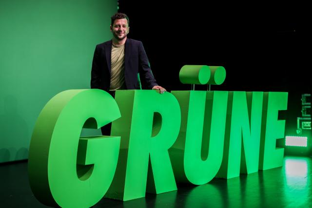 20 June 2026, North Rhine-Westphalia, Troisdorf: Co-chair of the Alliance 90/The Greens party Felix Banaszak stands behind the word "Grüne" (Greens), written in large letters on the stage, during the party's state convention. Photo: Christoph Reichwein/dpa