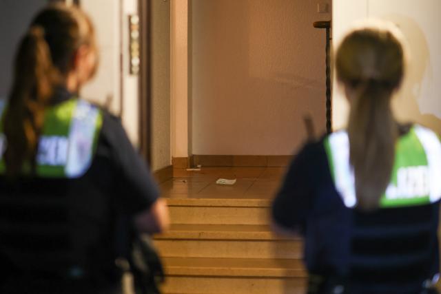 20 June 2026, North Rhine-Westphalia, Krefeld: Traces of blood can be seen in the stairwell of an apartment building; two female police officers are securing the crime scene. A police officer shot and fatally wounded a man armed with a knife in the city of Krefeld, North Rhine-Westphalia. Photo: Christoph Reichwein/dpa