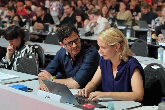 21 June 2026, Brandenburg, Potsdam: Luigi Pantisano and Ines Schwerdtner, co-chairs of The Left, talk during the party's national convention at the Metropolis Halle. The three-day convention focuses on electing the party's executive committee and debating current political issues. Photo: Michael Bahlo/dpa