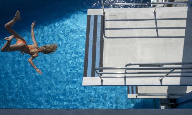 21 June 2026, Bavaria, Munich: A young woman dives headfirst into the water at Michaelibad. The weather is expected to remain hot and summery in the coming days. Photo: Stefan Puchner/dpa