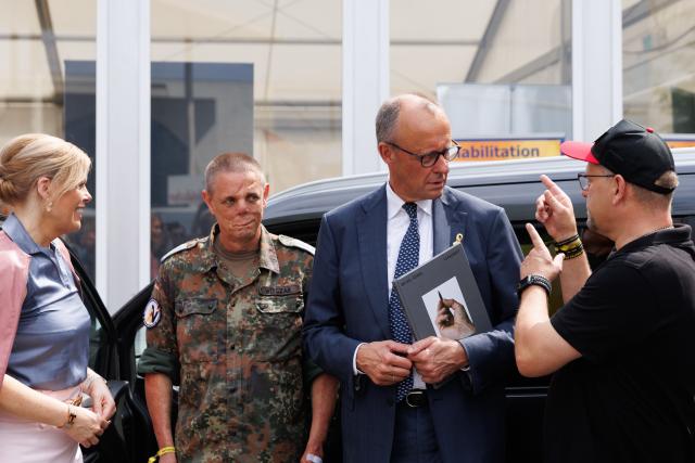 21 June 2026, Berlin: German Chancellor Friedrich Merz (2nd R) and German Bundestag President Julia Kloeckner (L) are pictured during a tour of the festivities marking the 2nd National Veterans Day. Germany is celebrating the 2nd National Veterans Day with a large ceremony around the Reichstag building. Photo: Carsten Koall/dpa