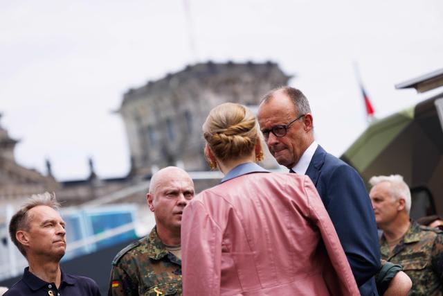21 June 2026, Berlin: German Chancellor Friedrich Merz (2nd R) and German Bundestag President Julia Kloeckner (L) are pictured during a tour of the festivities marking the 2nd National Veterans Day. Germany is celebrating the 2nd National Veterans Day with a large ceremony around the Reichstag building. Photo: Carsten Koall/dpa