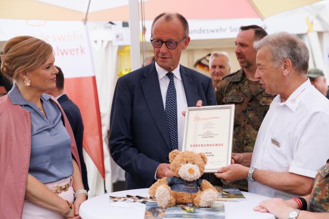 21 June 2026, Berlin: German Chancellor Friedrich Merz (2nd R) and German Bundestag President Julia Kloeckner (L) are pictured during a tour of the festivities marking the 2nd National Veterans Day. Germany is celebrating the 2nd National Veterans Day with a large ceremony around the Reichstag building. Photo: Carsten Koall/dpa