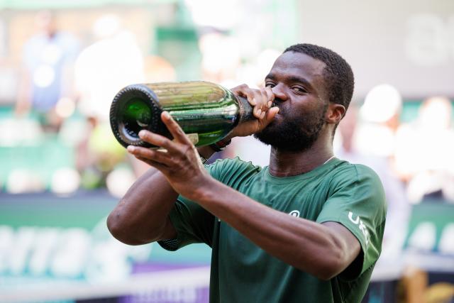 21 June 2026, North Rhine-Westphalia, Halle (Westfalen): US tennis player Frances Tiafoe holds the trophy after his victory over against US Taylor during the Halle Open tennis tournament. Photo: Friso Gentsch/dpa