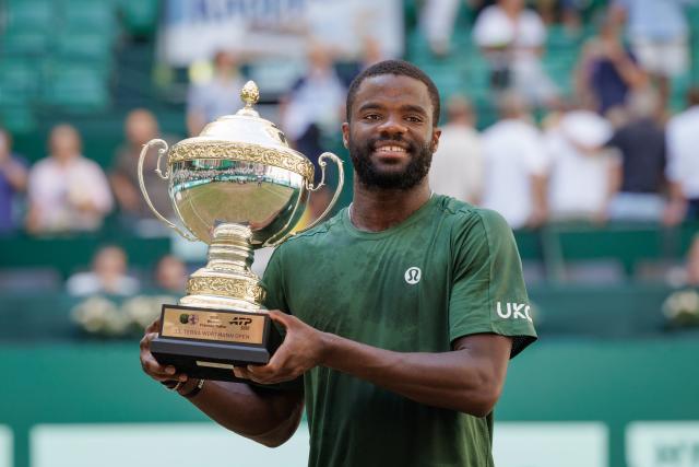 21 June 2026, North Rhine-Westphalia, Halle (Westfalen): US tennis player Frances Tiafoe holds the trophy after his victory over against US Taylor during the Halle Open tennis tournament. Photo: Friso Gentsch/dpa