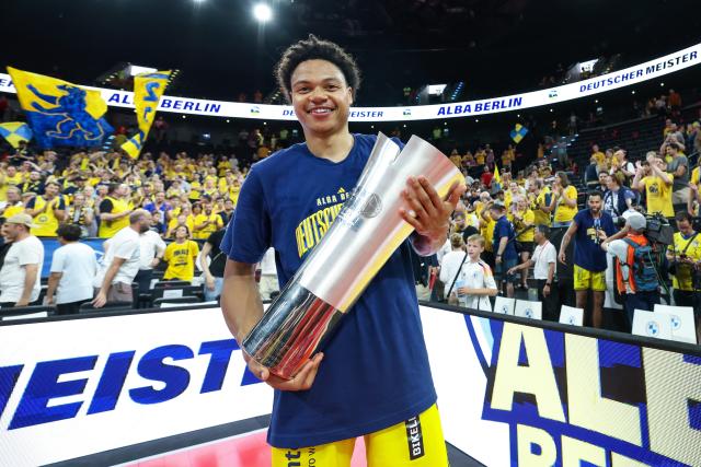 21 June 2026, Bavaria, Munich: ALBA Berlin's Jack Kayil celebrates holding the trophy after the German Basketball Bundesliga final match between ALBA Berlin and Bayern Munich at SAP Garden. Photo: Matthias Stickel/dpa