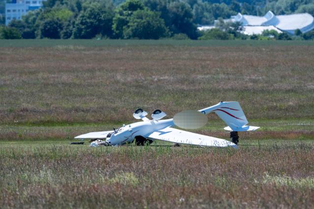 22 June 2026, Mecklenburg-Vorpommern, Kramerhof: A small motorized aircraft lies on the runway at the Stralsund-Kedingshagen Airfield following an accident. According to police, the aircraft sustained property damage of approximately 50,000 euros. The investigation into the cause of the accident is ongoing. Photo: Stefan Sauer/dpa - ATTENTION: individual(s) has/have been pixelated for legal reasons