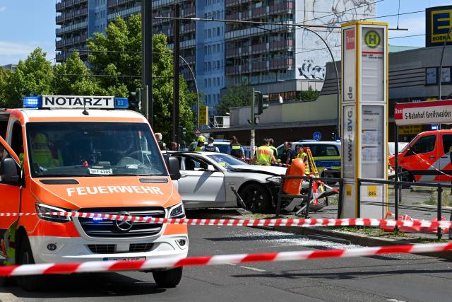 23 June 2026, Berlin: Police and fire department personnel are on the scene of a serious traffic accident at a tram stop at the corner of Greifswalder Straße and Grellstraße. One person has died in the accident involving two cars. Photo: Jens Kalaene/dpa