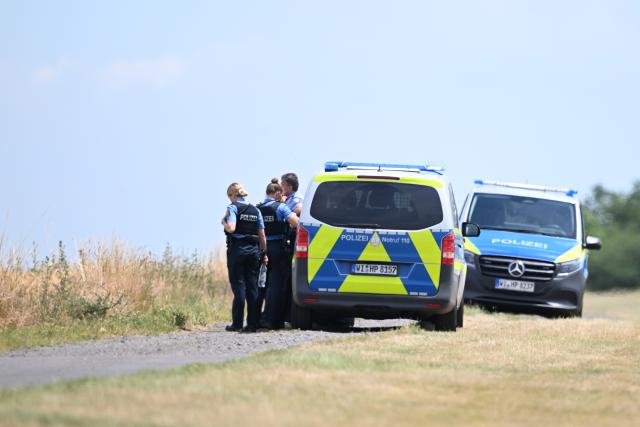 23 June 2026, Hesse, Pohlheim: Police officers are stationed near the crash site of a small aircraft at the glider airfield in the Watzenborn-Steinberg district of Pohlheim. The rescue operation is underway, according to the Central Hesse Police Headquarters. Photo: Florian Wiegand/dpa