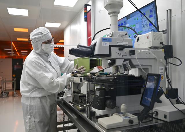 23 June 2026, Thuringia, Erfurt: An employee works in the clean-room of the Erfurt-based chip manufacturer X-FAB. The X-FAB Group, which has factories in Erfurt and Dresden as well as in France, Malaysia, and the US, employs more than 4,000 people, according to the company. In Erfurt, where the company has its roots, there are currently more than 800 employees. Photo: Martin Schutt/dpa