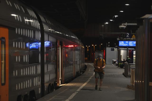 23 June 2026, North Rhine-Westphalia, Duisburg: A passenger walks on a platform in front of a train at Duisburg Central Station. Germany's Deutsche Bahn temporarily suspended its train services nationwide on Tuesday evening following a disruption to its communications system, the state-owned rail operator said. Photo: Christoph Reichwein/dpa