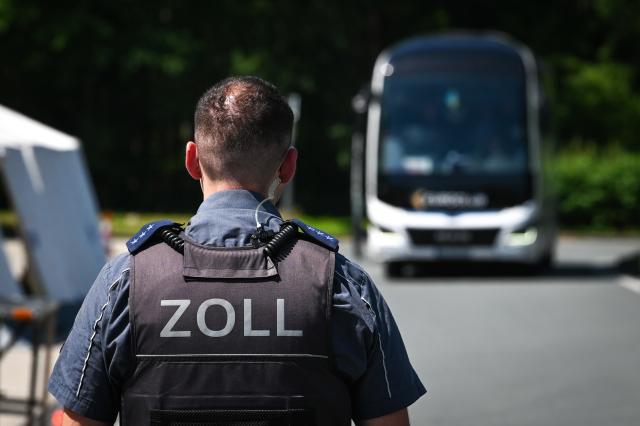 24 June 2026, Thuringia, Hermsdorfer Kreuz: A customs officer and a bus pull into the lot for an inspection. At the Hermsdorfer Kreuz rest stop, customs officials are conducting a travel inspection in cooperation with the police. The focus is primarily on tour buses. Photo: Heiko Rebsch/dpa