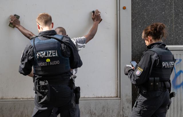 FILED - 23 June 2026, Hesse, Frankfurt am Main: Police officers search a suspected drug dealer during a raid in Frankfurt's train station district. The streets of the red-light district are considered Germany's drug hotspot because of its open drug scene. Photo: Boris Roessler/dpa