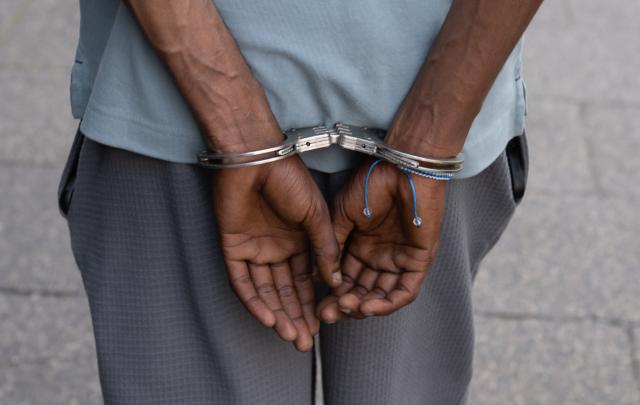 FILED - 23 June 2026, Hesse, Frankfurt am Main: A suspected drug dealer is handcuffed during a raid in Frankfurt's train station district. The streets of the red-light district are considered Germany's drug hotspot because of its open drug scene. Photo: Boris Roessler/dpa