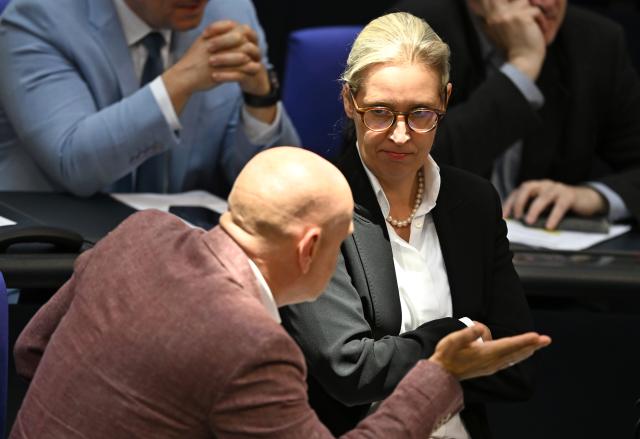 25 June 2026, Berlin: Alice Weidel, Alternative for Germany party chairwoman and parliamentary group leader, speaks with fellow Alternative for Germany lawmaker Enrico Komning in the plenary chamber of the German Bundestag. Photo: Elisa Schu/dpa