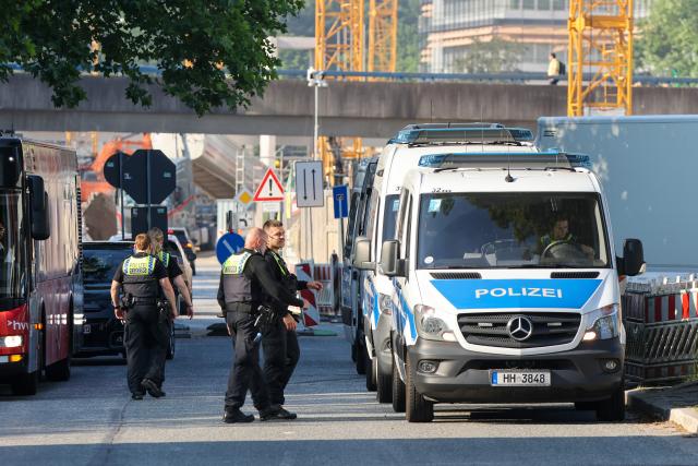 25 June 2026, Hamburg: Police officers stand near a refugee shelter during a police operation in Hamburg. Officers searched the facility while providing administrative assistance to the Federal Employment Agency. Photo: Bodo Marks/dpa