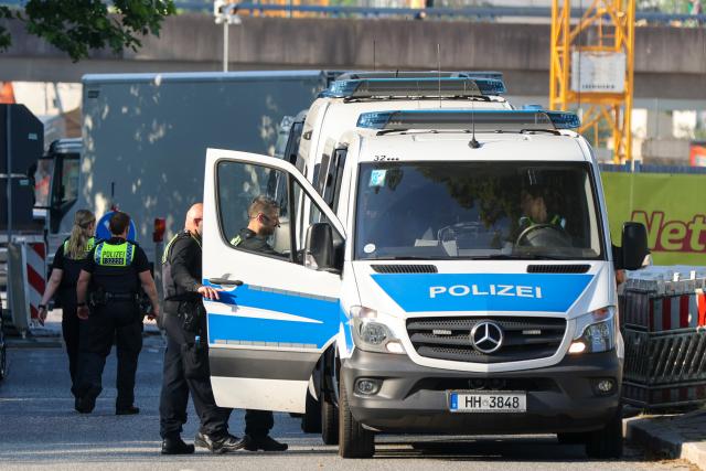 25 June 2026, Hamburg: Police officers stand near a refugee shelter during a police operation in Hamburg. Officers searched the facility while providing administrative assistance to the Federal Employment Agency. Photo: Bodo Marks/dpa